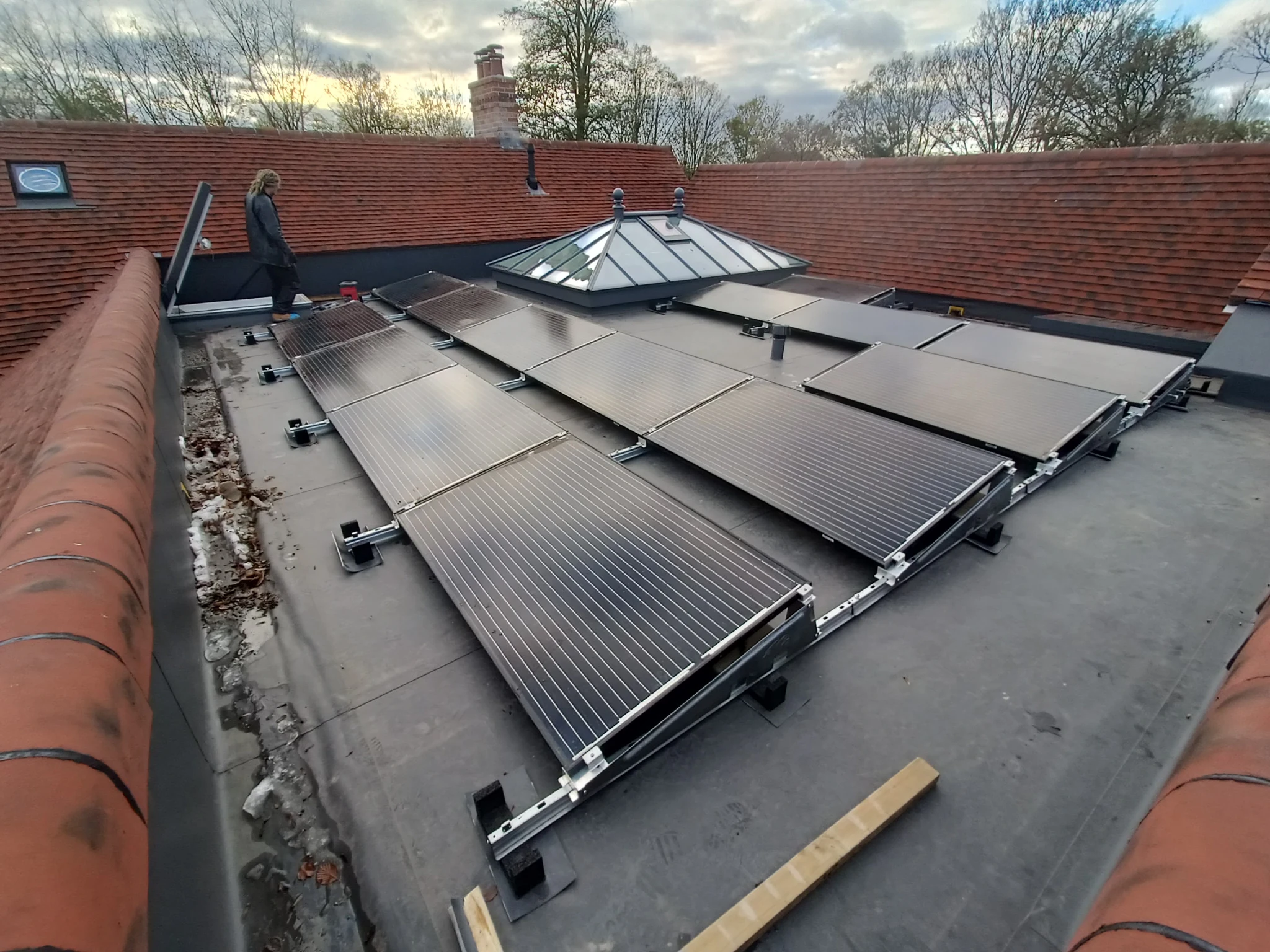 Solar panels being refitted on a flat roof near Alton