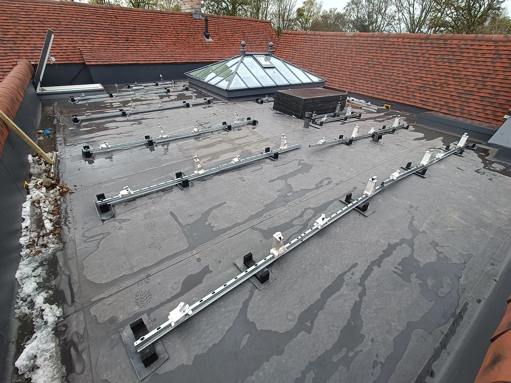 Van der Valk flat roof mounting rails laid out ready for solar PV reinstallation near Alton